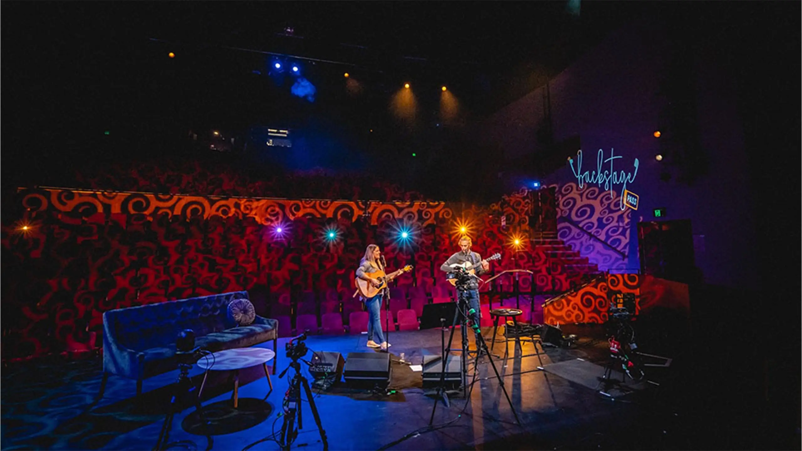 Two musicians playing guitars on stage