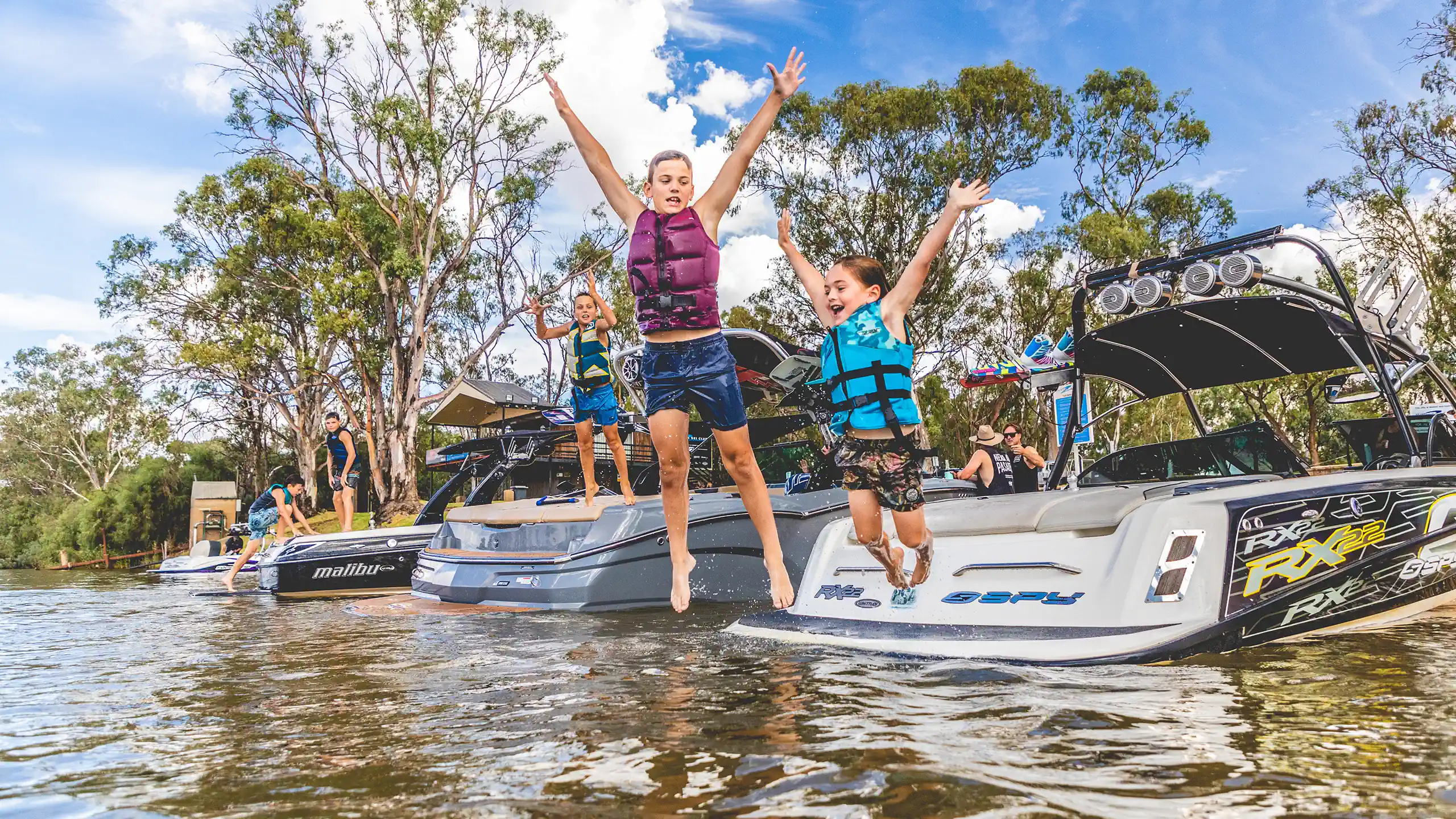 Three kids jumping into the Murray River.