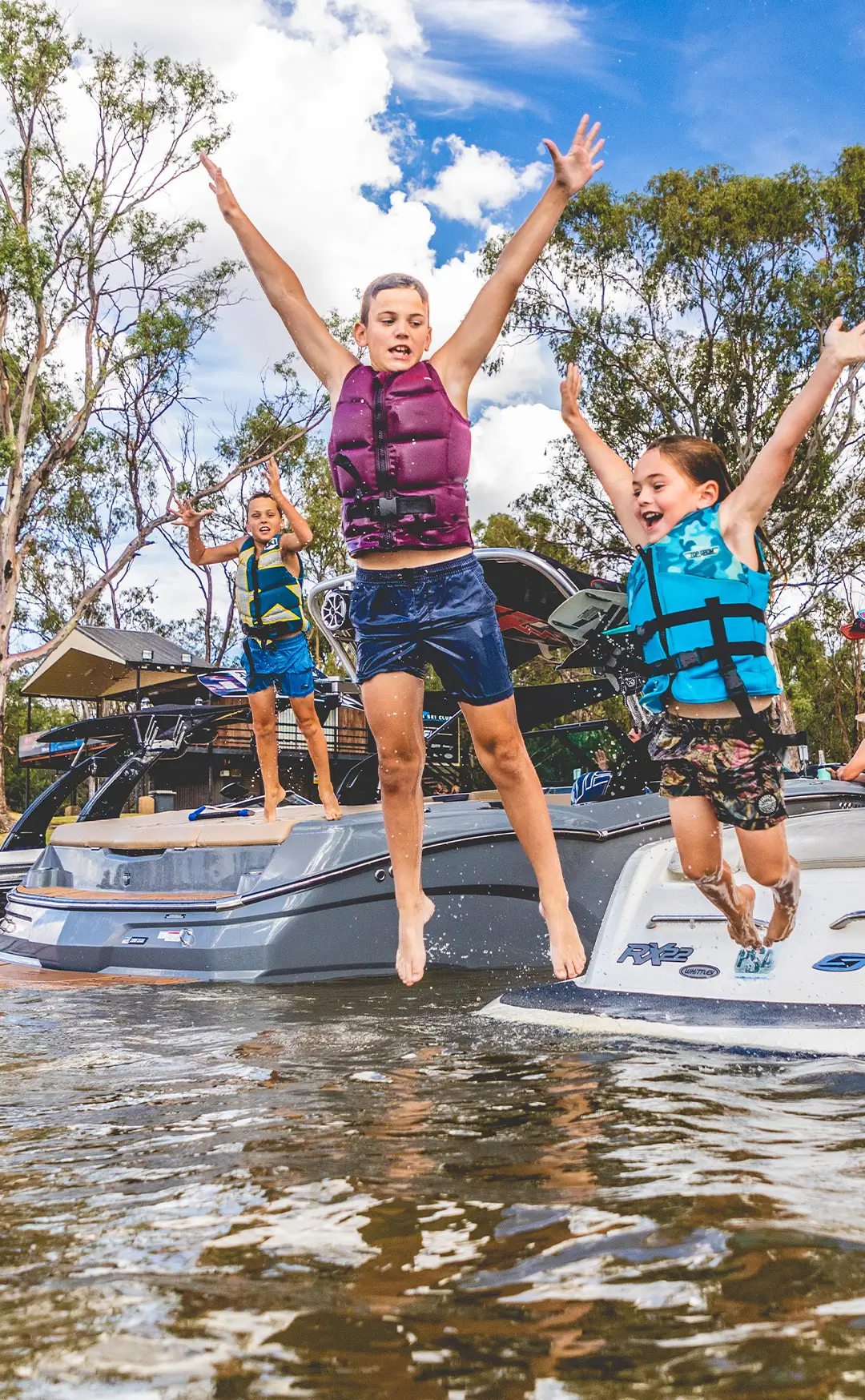 Three kids jumping into the Murray River.