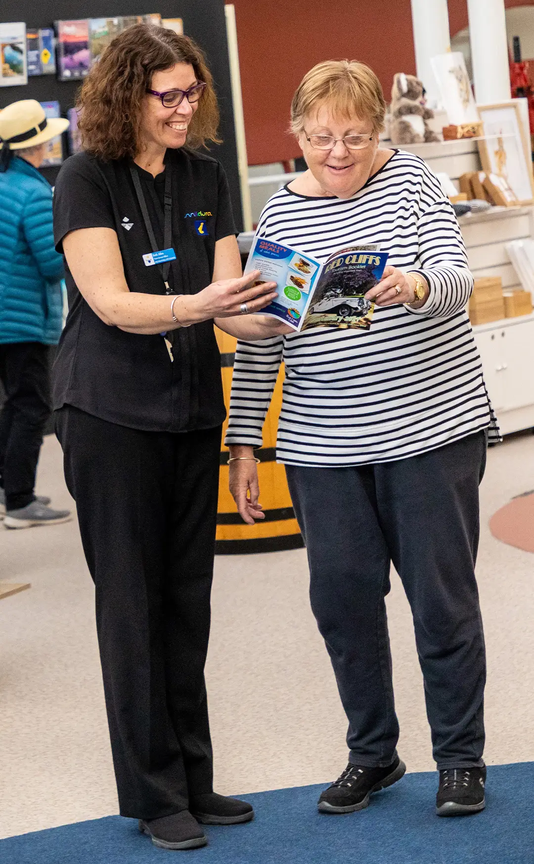 A staff member offering customer service to an elderly female visitor at Mildura Visitor Information Centre.