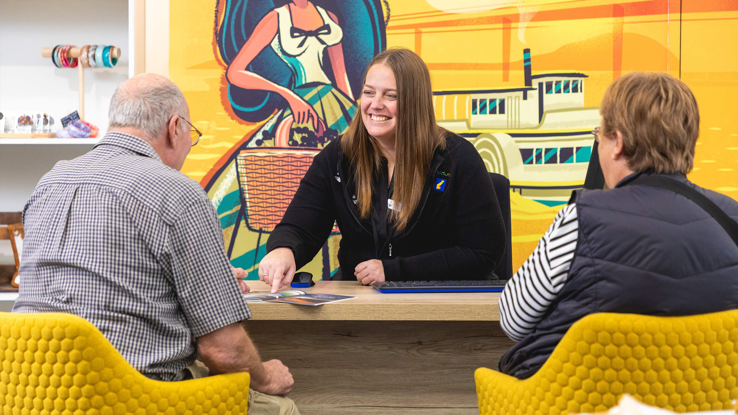 An expert helping a tourist at the Mildura information centre